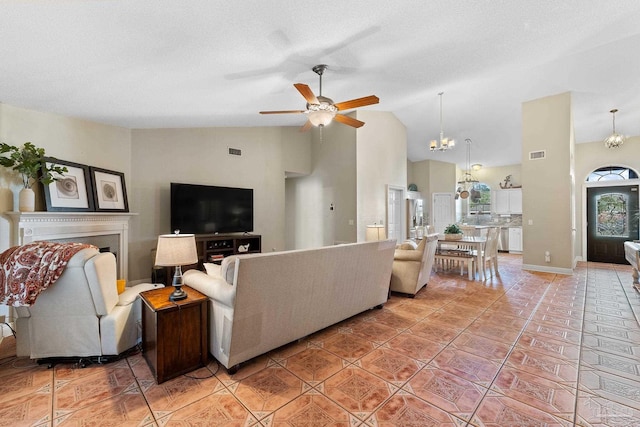 living room featuring light tile patterned floors, ceiling fan with notable chandelier, and high vaulted ceiling