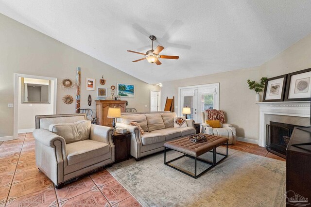 tiled living room with ceiling fan, a textured ceiling, and vaulted ceiling