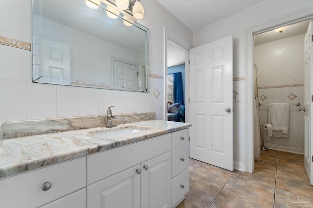 bathroom featuring vanity, backsplash, tile patterned floors, and tile walls