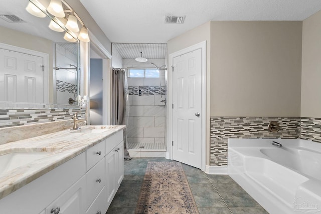 bathroom with a textured ceiling, tile patterned floors, and separate shower and tub