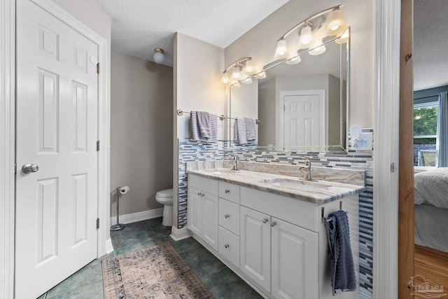 bathroom featuring tile patterned floors, vanity, backsplash, and a textured ceiling