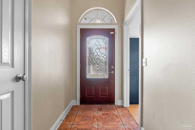 doorway to outside with light tile patterned floors