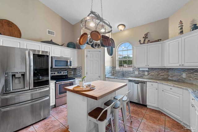 kitchen featuring white cabinets, stainless steel appliances, and a kitchen island