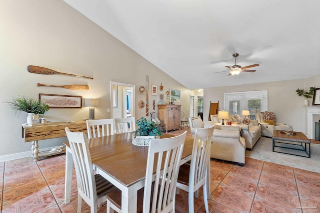 tiled dining space featuring ceiling fan, french doors, and vaulted ceiling