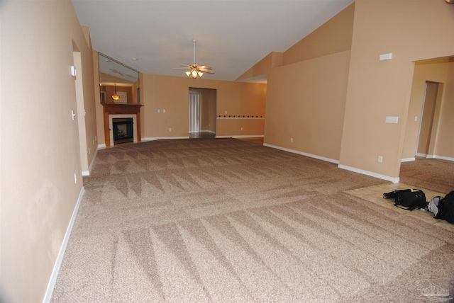 unfurnished living room with ceiling fan, carpet floors, and vaulted ceiling