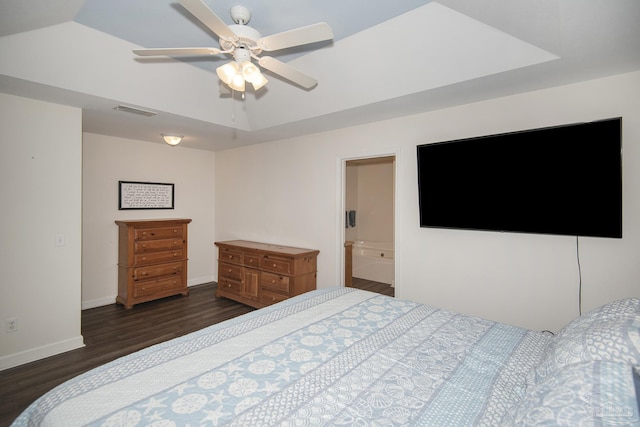 bedroom featuring dark wood-type flooring, ceiling fan, and a tray ceiling