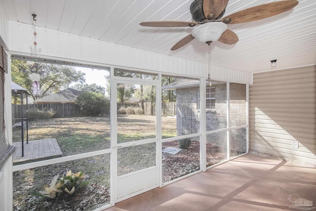 unfurnished sunroom featuring ceiling fan