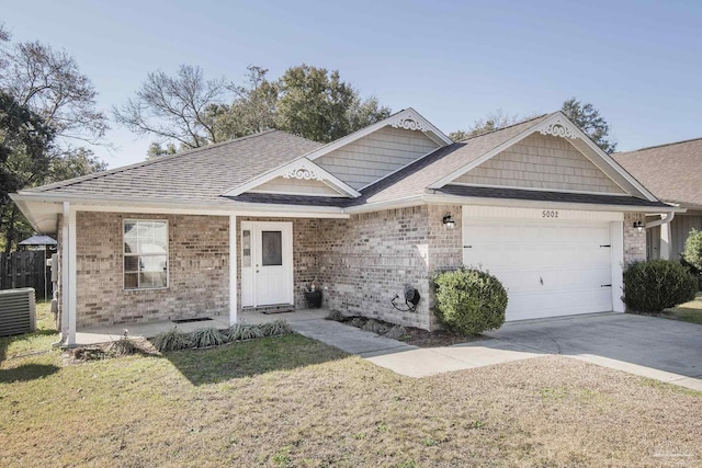 view of front facade featuring a garage, a front yard, and central AC unit