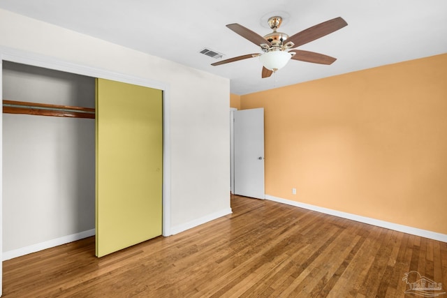 unfurnished bedroom with ceiling fan, a closet, and hardwood / wood-style flooring