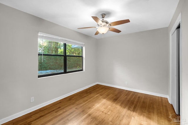 unfurnished bedroom featuring ceiling fan, a closet, and wood-type flooring