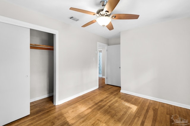 unfurnished bedroom with ceiling fan, a closet, and wood-type flooring