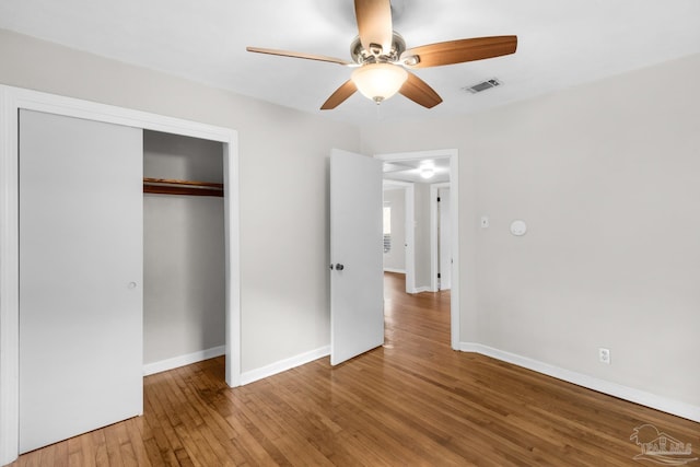 unfurnished bedroom featuring wood-type flooring, a closet, and ceiling fan