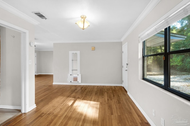 interior space with wood-type flooring, plenty of natural light, and crown molding