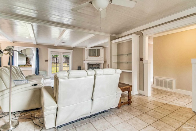 tiled living room featuring french doors, ceiling fan, built in features, beam ceiling, and wood ceiling