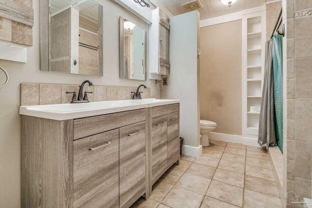 bathroom featuring tile patterned flooring, vanity, and toilet