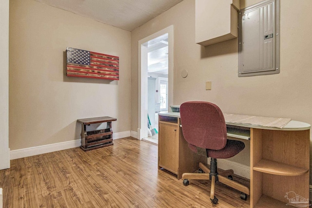 home office featuring electric panel and light hardwood / wood-style flooring