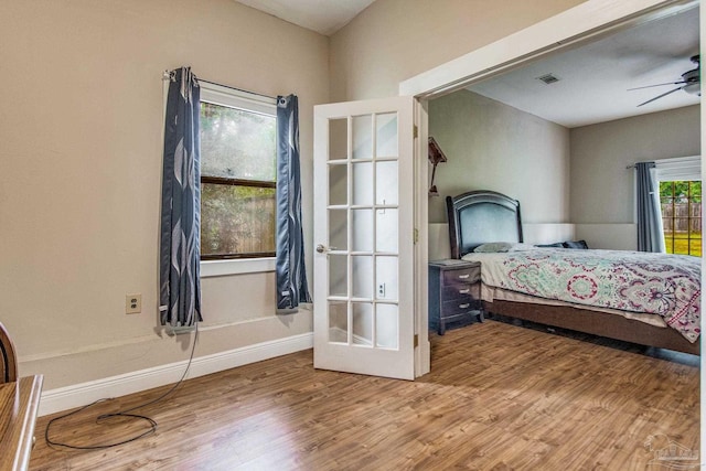 bedroom featuring ceiling fan, french doors, and wood-type flooring