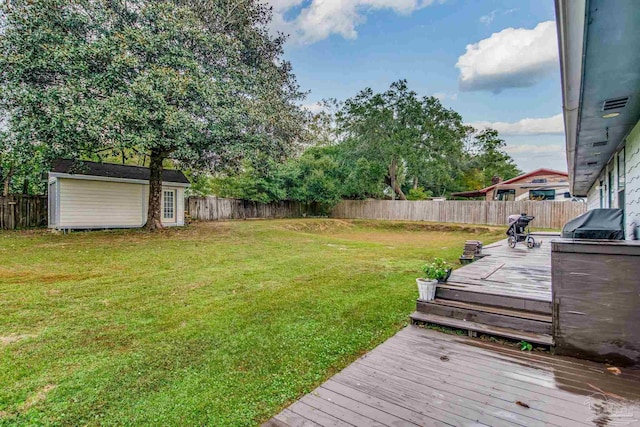 view of yard with a wooden deck and a storage unit