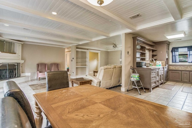 tiled dining room with beamed ceiling, ceiling fan, and sink