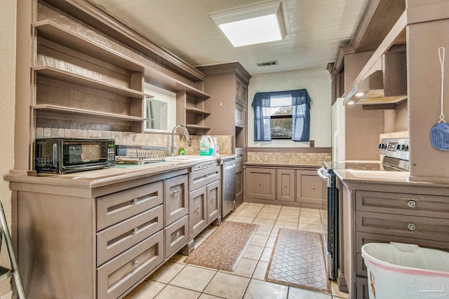 kitchen featuring dishwasher, wall chimney range hood, range with electric cooktop, decorative backsplash, and light tile patterned floors