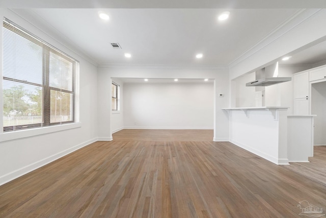 unfurnished living room featuring crown molding, light wood-style flooring, and baseboards