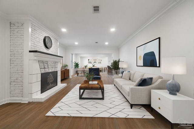 living room featuring hardwood / wood-style flooring, ornamental molding, and a fireplace