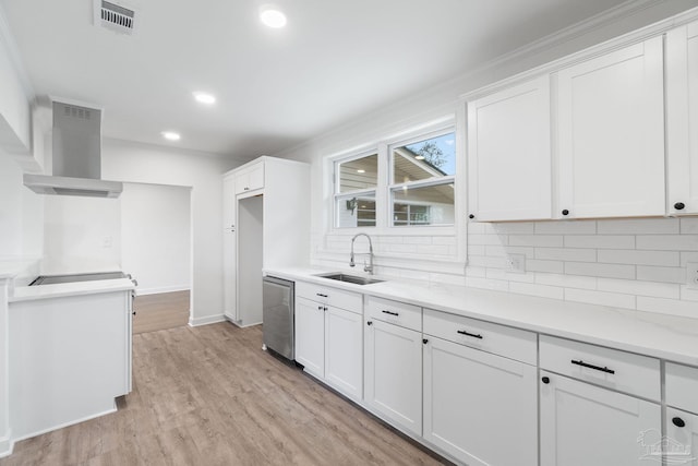 kitchen with light wood-type flooring, backsplash, stainless steel dishwasher, sink, and white cabinetry