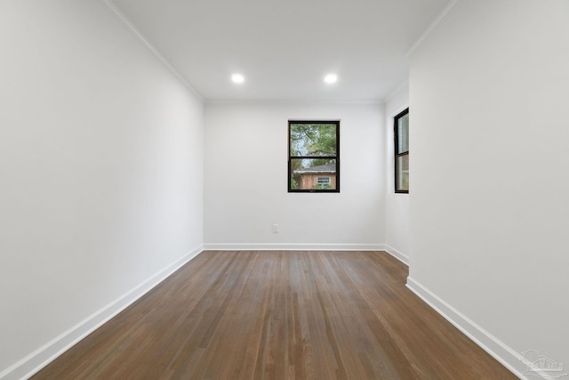 unfurnished room with dark wood finished floors, baseboards, and ornamental molding