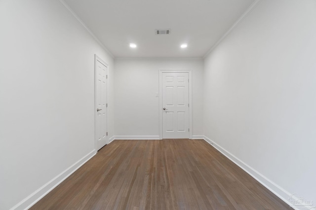 unfurnished room featuring visible vents, baseboards, dark wood-style flooring, and crown molding