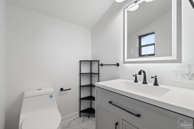 bathroom with toilet, vanity, and vaulted ceiling