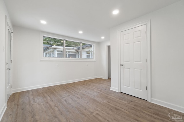 unfurnished bedroom with recessed lighting, baseboards, and wood finished floors