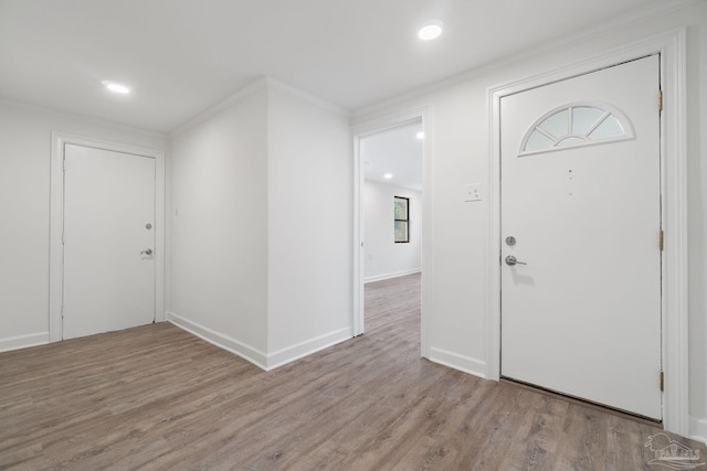 entryway with light hardwood / wood-style floors and crown molding