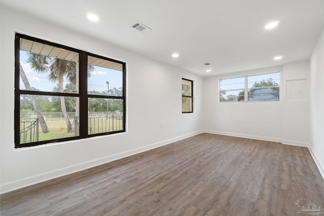 spare room with recessed lighting, visible vents, baseboards, and wood finished floors