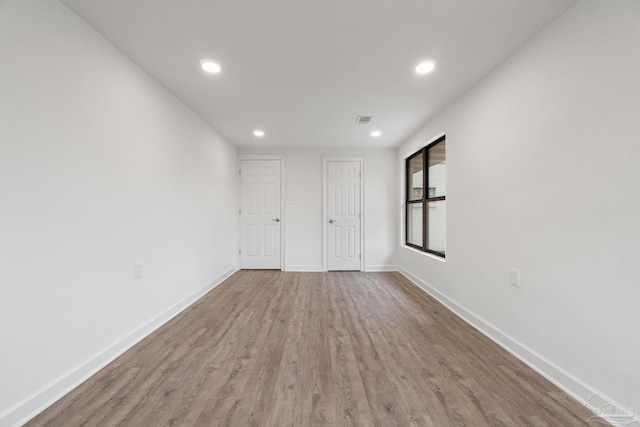 unfurnished room with recessed lighting, visible vents, baseboards, and wood finished floors