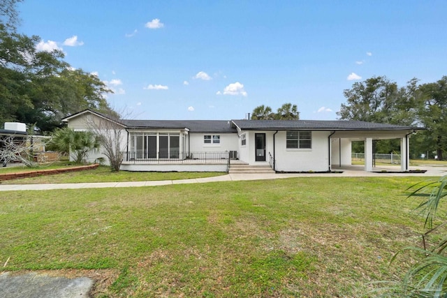 back of property with a yard, stucco siding, and a sunroom