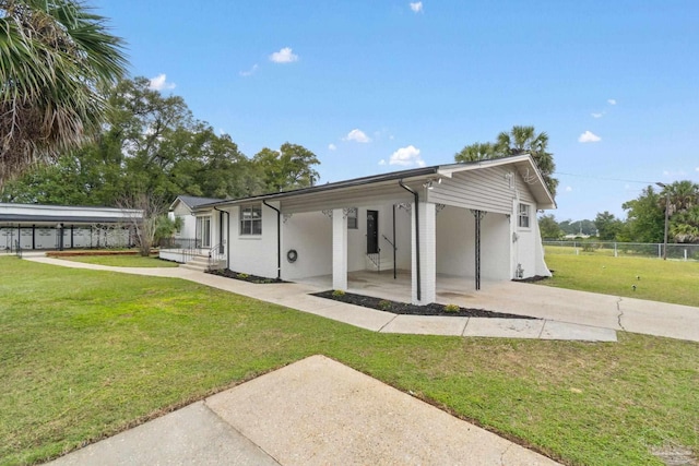 rear view of property featuring a yard and a carport