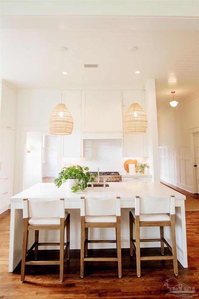 dining room featuring dark hardwood / wood-style flooring, sink, crown molding, and breakfast area