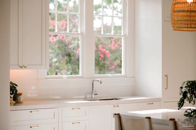 kitchen with white cabinetry, sink, backsplash, and plenty of natural light