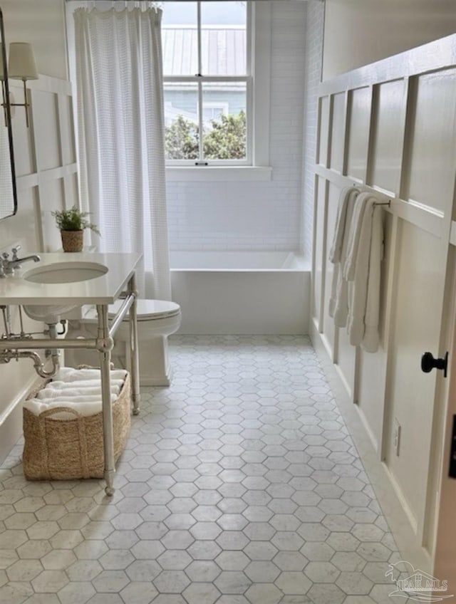 bathroom with sink, a bathtub, and toilet