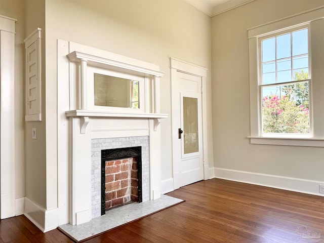 unfurnished living room featuring dark hardwood / wood-style floors, crown molding, and a fireplace