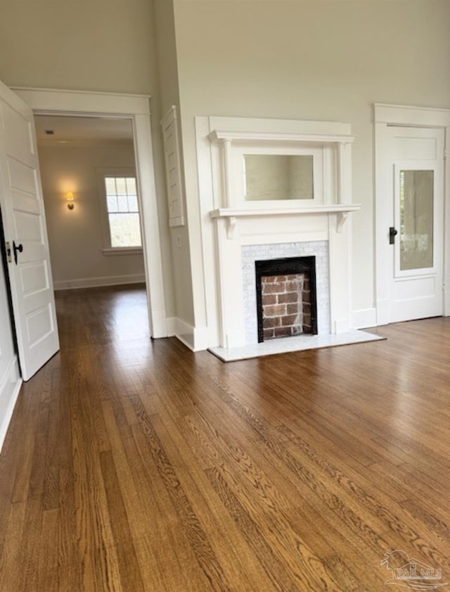 1524 E Strong St, Pensacola, FL 32501 - unfurnished living room with baseboards, dark wood-type flooring, and a fireplace with flush hearth