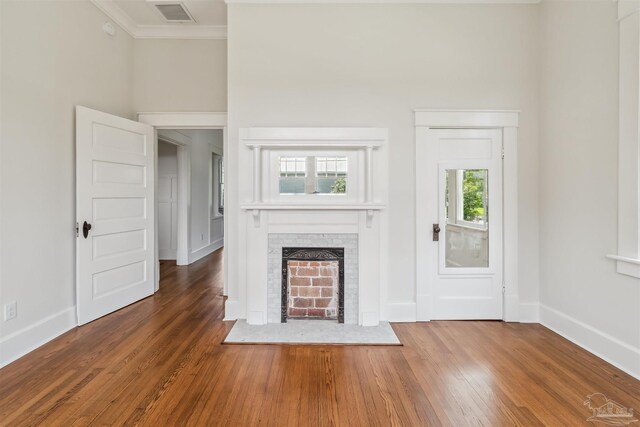 1524 E Strong St, Pensacola, FL 32501 - unfurnished living room featuring crown molding, wood finished floors, a brick fireplace, and baseboards