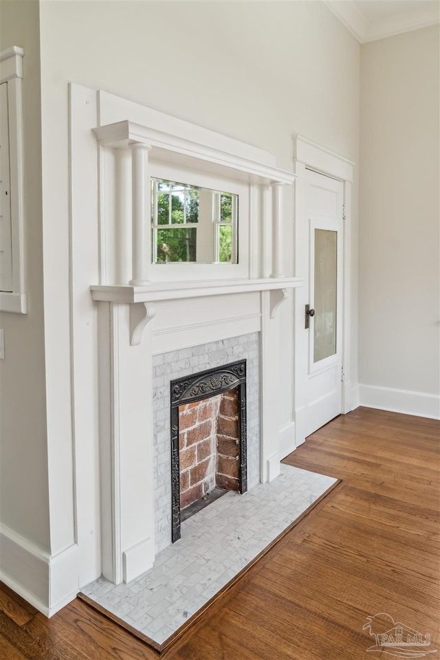 1524 E Strong St, Pensacola, FL 32501 - unfurnished living room featuring baseboards, wood finished floors, a tiled fireplace, and crown molding
