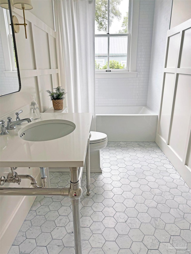 bathroom with toilet, tile patterned floors, and sink