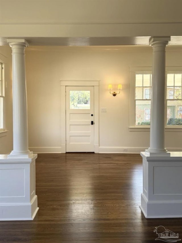 foyer featuring ornamental molding, dark hardwood / wood-style floors, and ornate columns