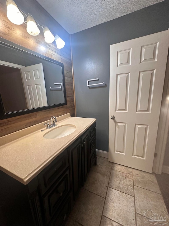 bathroom featuring vanity, baseboards, and a textured ceiling