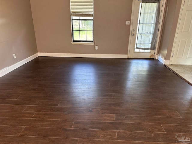 spare room with dark wood-style floors and baseboards