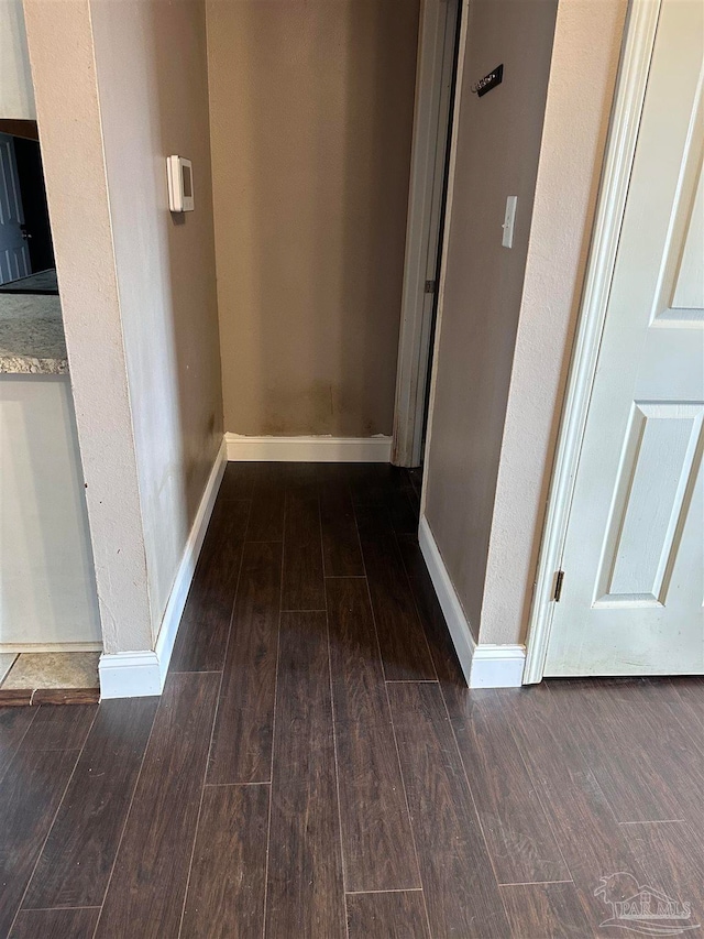 hall featuring wood finished floors and baseboards