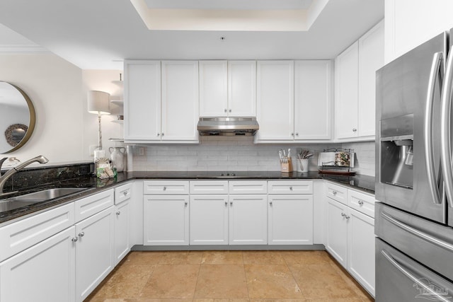 kitchen featuring stainless steel fridge, backsplash, white cabinetry, and sink