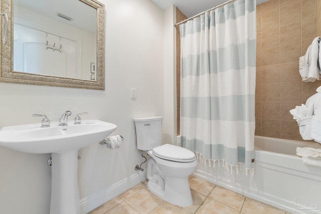 full bathroom with tile patterned floors, sink, shower / tub combo with curtain, and toilet